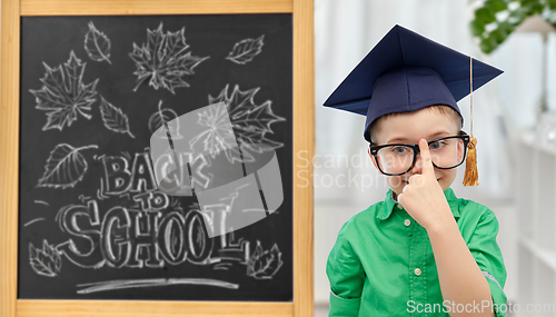 Image of little student boy in bachelor hat and eyeglasses