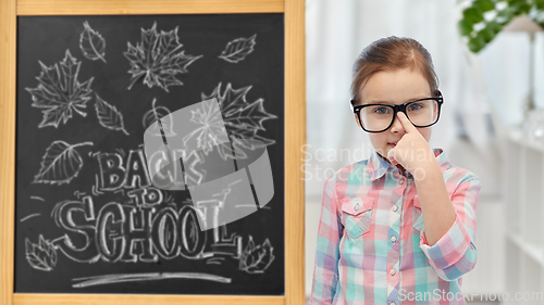 Image of little student girl in glasses over chalkboard