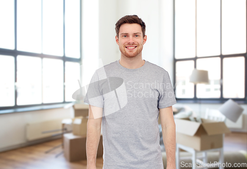Image of smiling young man in gray t-shirt at new home