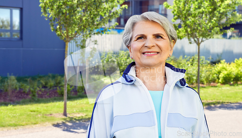 Image of smiling sporty senior woman in city