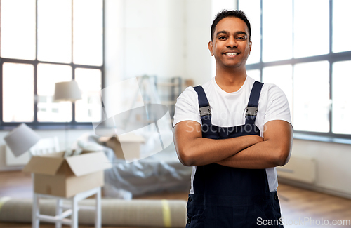 Image of happy indian worker with crossed arms at new home