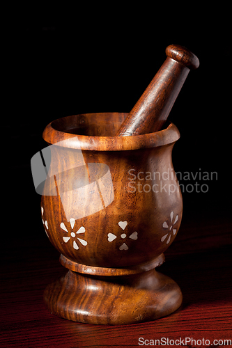 Image of Wooden mortar and pestle on dark