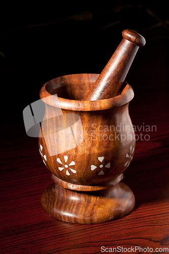 Image of Wooden mortar and pestle on dark