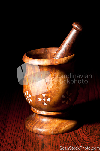 Image of Wooden mortar and pestle on dark