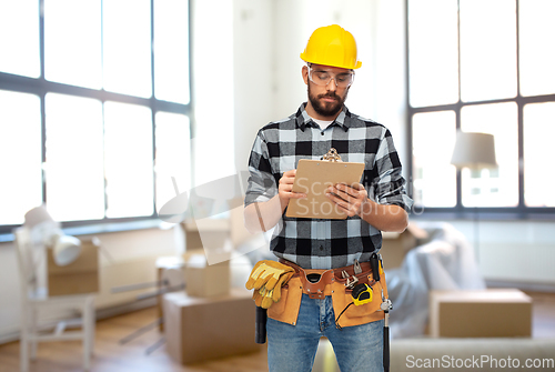 Image of male builder in helmet with clipboard at home