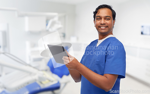 Image of smiling doctor using tablet pc at dental office