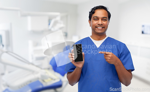 Image of smiling doctor with smartphone at dental office