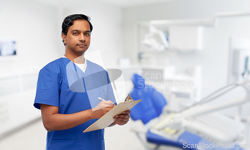 Image of male doctor with clipboard at dental office