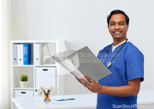 Image of happy indian doctor with medical report in folder