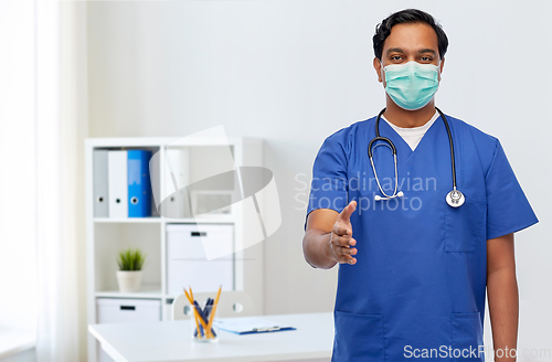 Image of indian male doctor in blue uniform and mask