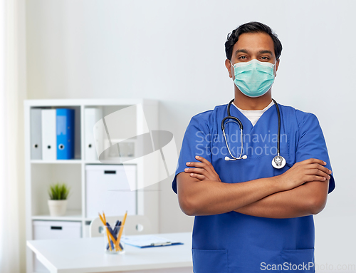 Image of indian male doctor in blue uniform and mask