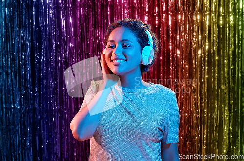 Image of woman in headphones listening to music and dancing