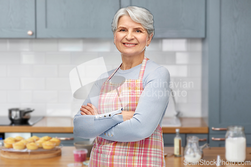 Image of portrait of smiling senior woman at kitchen