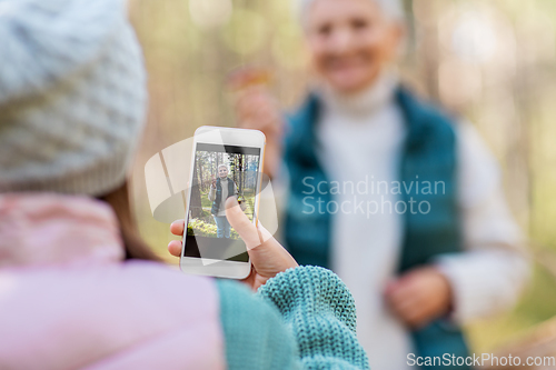 Image of granddaughter photographing grandma with mushrooms