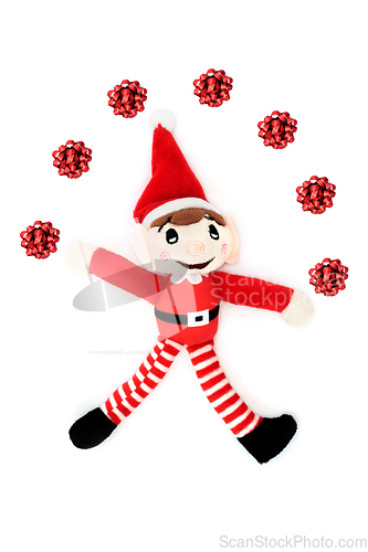 Image of Christmas Elf Juggling Red Bow Decorations