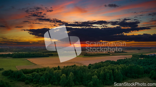 Image of Colorful sunset over forest and fields aerial