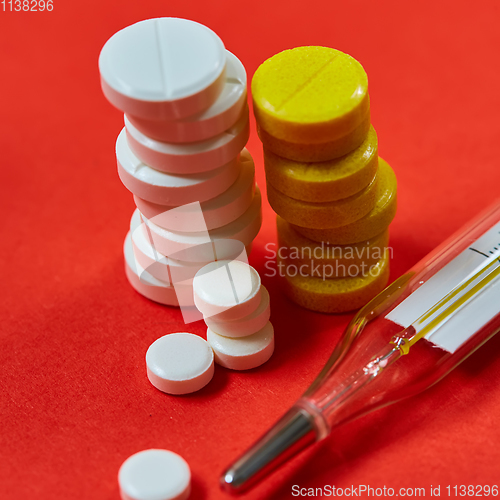 Image of Mercury thermometer and medical pills on background