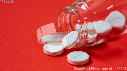 Image of Pills spilling out of pill bottle on red. Top view with copy space. 