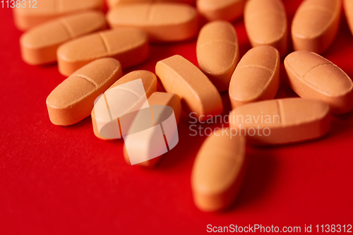 Image of Pills spilling out of pill bottle on red. Top view with copy space. 