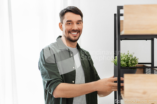Image of man decorating home with flower or houseplant