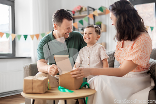 Image of happy family opening birthday presents at home