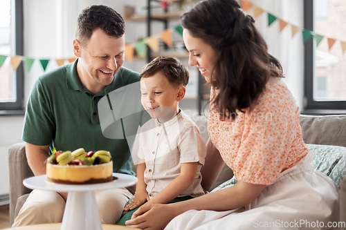 Image of happy family with birthday cake at home