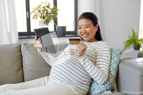 Image of pregnant woman with tablet pc and credit card