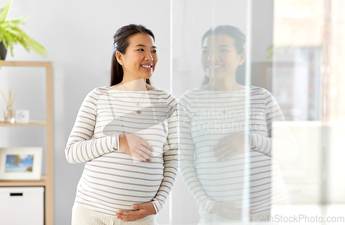 Image of happy pregnant asian woman at home