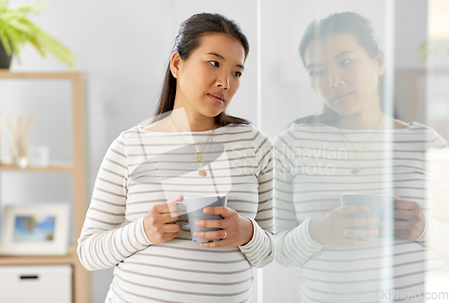 Image of sad pregnant woman drinking tea at home