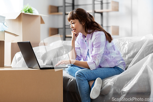Image of woman with laptop moving into new home