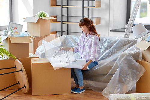 Image of woman with blueprint and boxes moving to new home