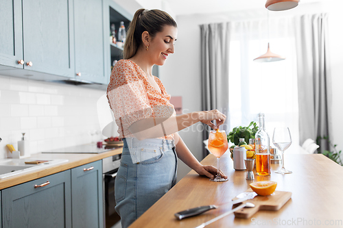 Image of woman making cocktail drinks at home kitchen