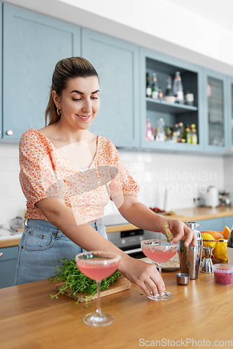 Image of woman making cocktail drinks at home kitchen