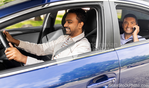 Image of male passenger calling on smartphone in taxi car