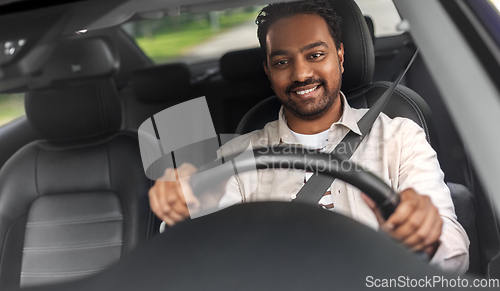 Image of smiling indian man or driver driving car