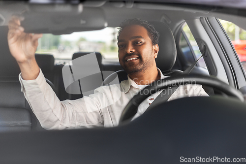 Image of smiling indian man or driver driving car