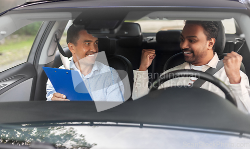 Image of smiling car driving school instructor and driver