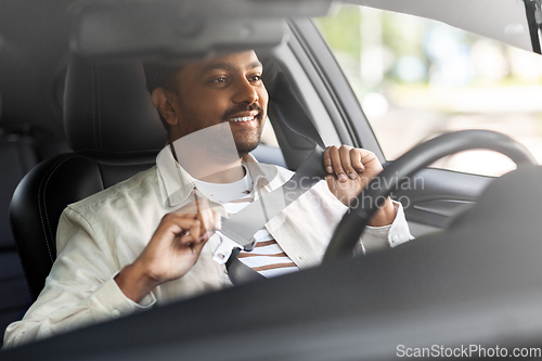 Image of smiling indian man or driver driving car