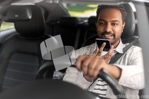 Image of man driving car and recording voice by smartphone