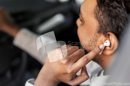 Image of man or driver with wireless earphones driving car