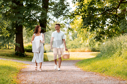 Image of happy couple with picnic basket at summer park