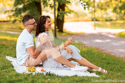 Image of happy couple having picnic at summer park
