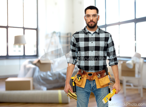 Image of male builder with tools and level at home