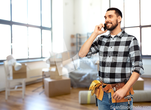 Image of builder in helmet calling on smartphone at home