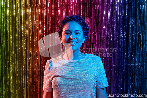 Image of african woman at party over rainbow curtain