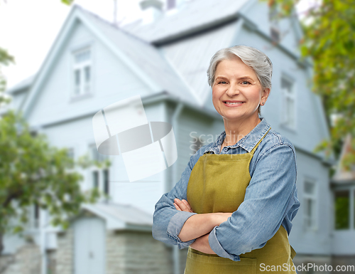 Image of portrait of smiling senior woman in garden apron