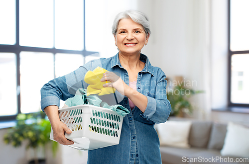 Image of smiling senior woman with laundry basket