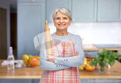 Image of smiling senior woman in apron with rolling pin