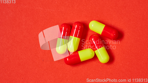 Image of Pills spilling out of pill bottle on red. Top view with copy space. 