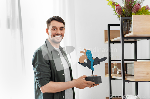 Image of man decorating home with art in frame